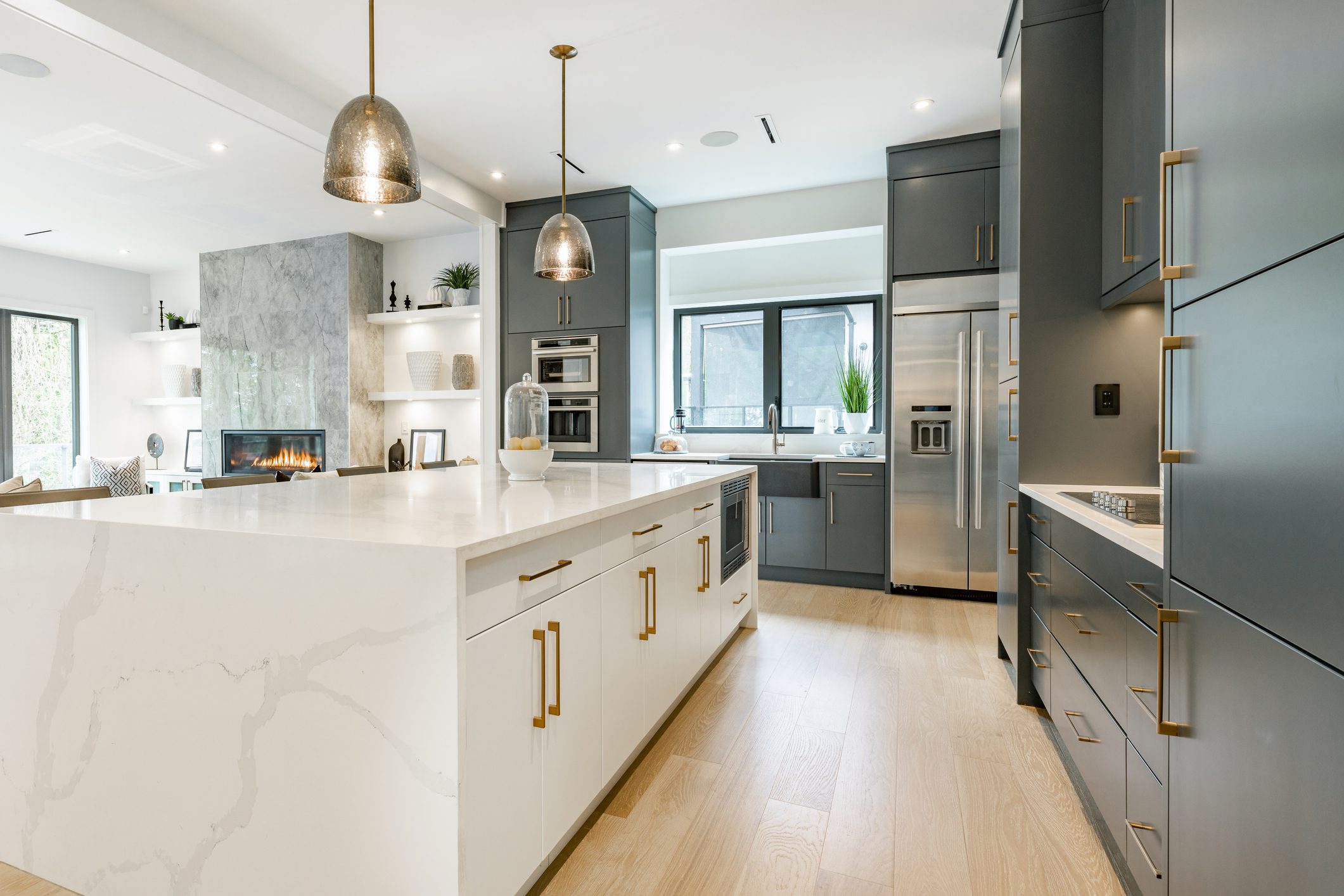 Modern kitchen with white island and gray cabinets.