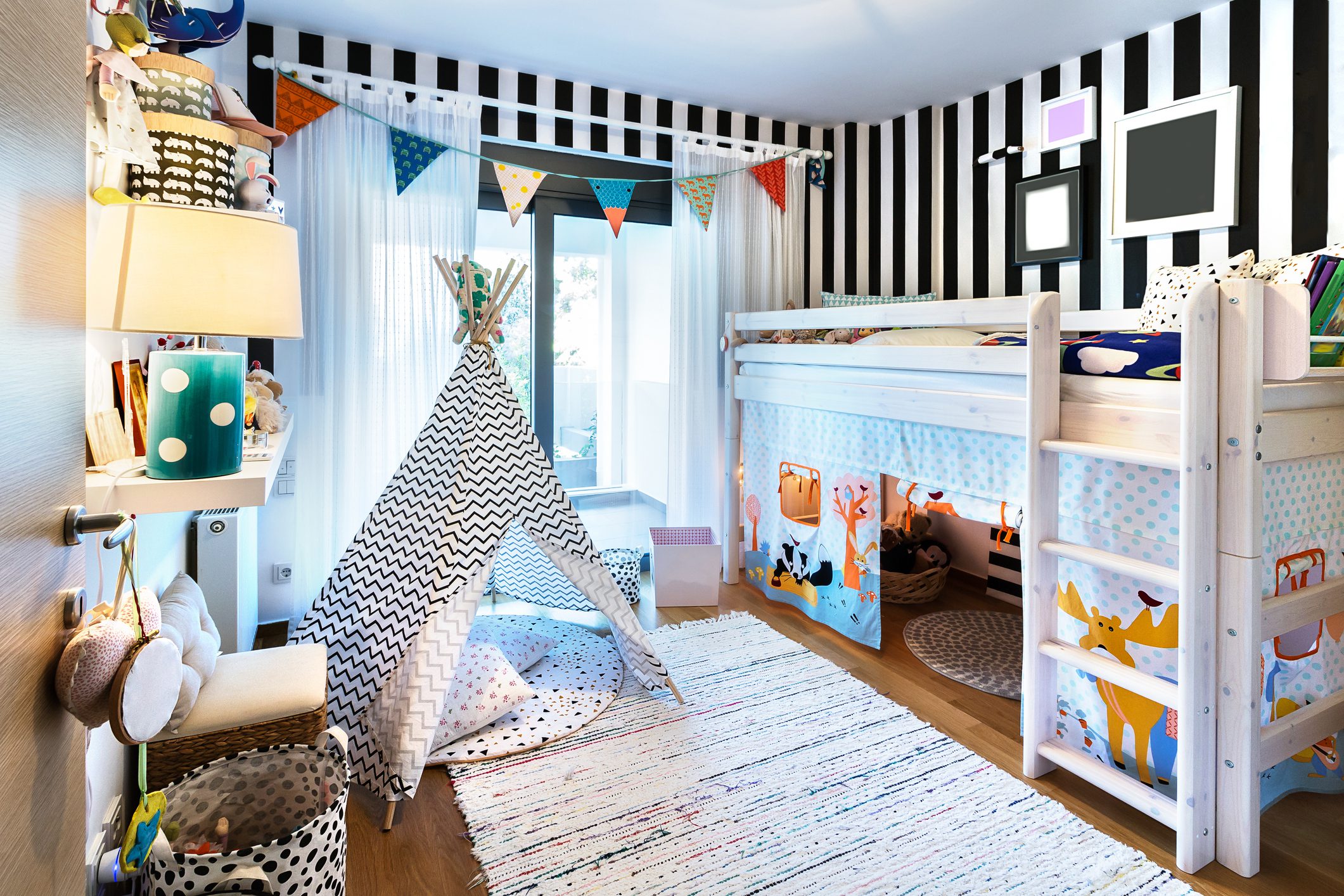 A vibrant kids' bedroom with a teepee, bunk bed, and colorful decor.