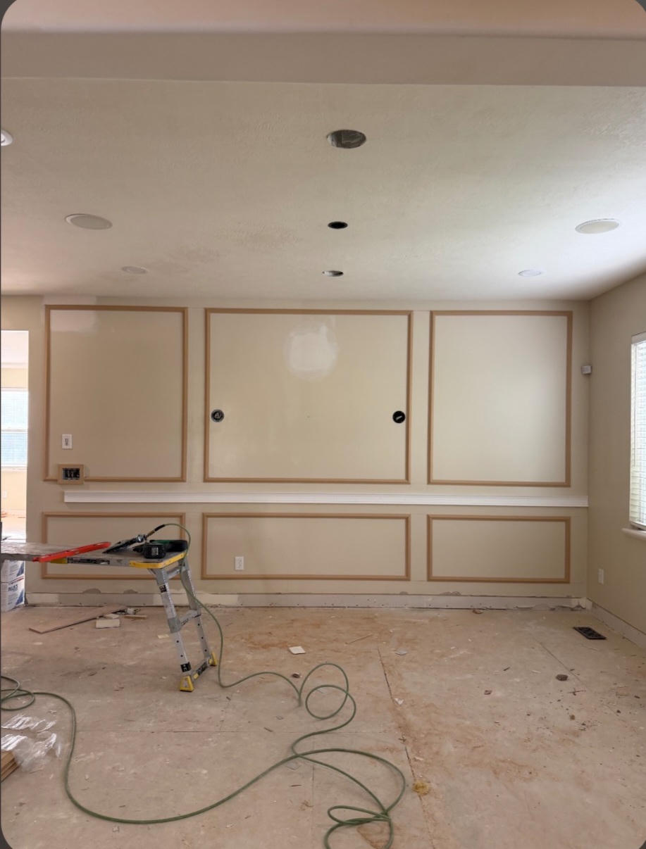 A room under renovation with decorative wall panels and construction tools.