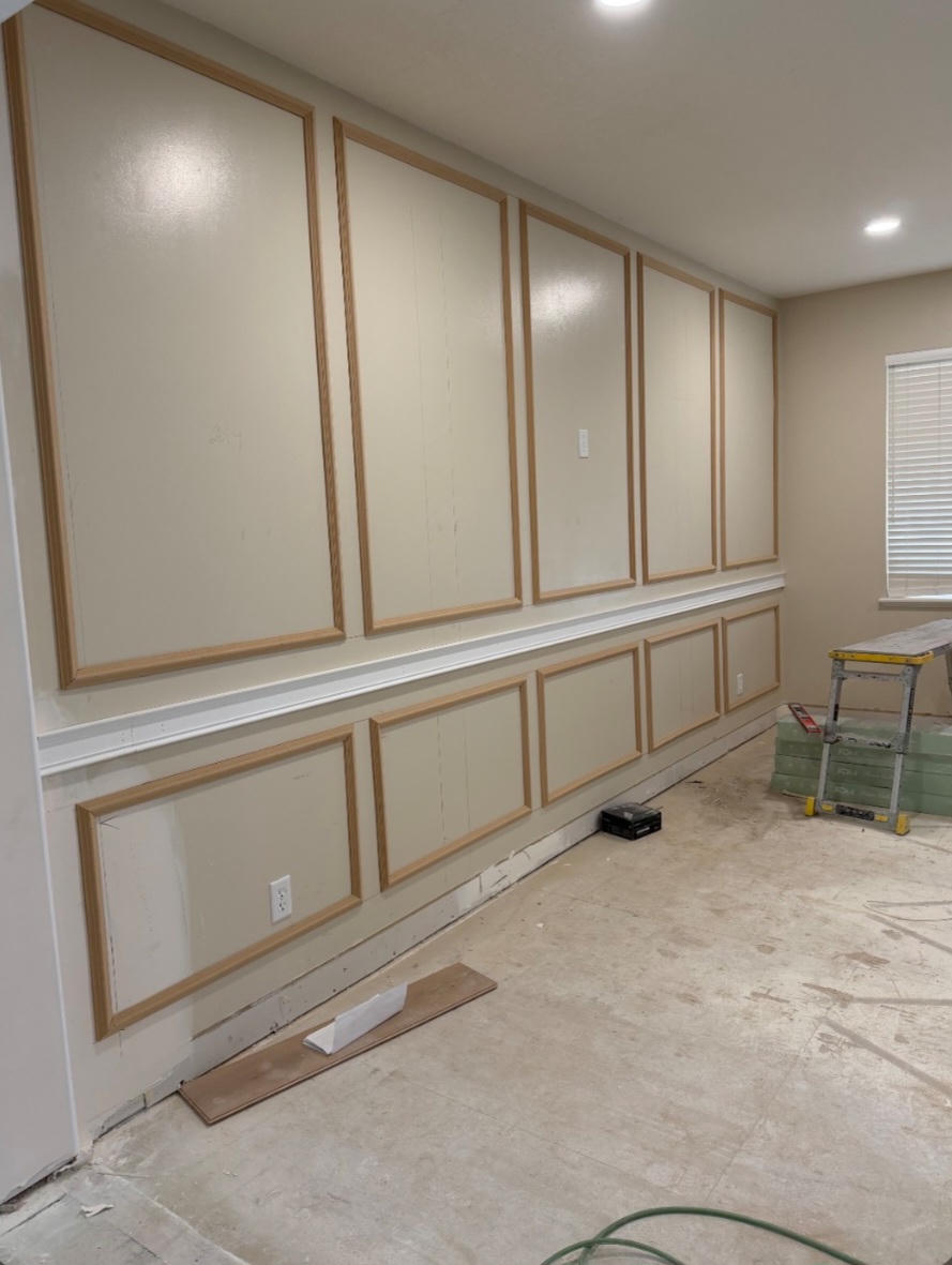 Wall panels with decorative molding in a room under renovation.
